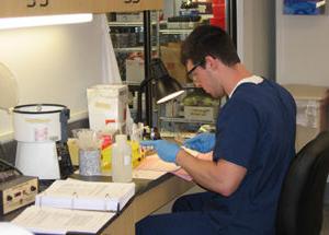 Student performing immunohematology (blood bank) techniques in student lab.